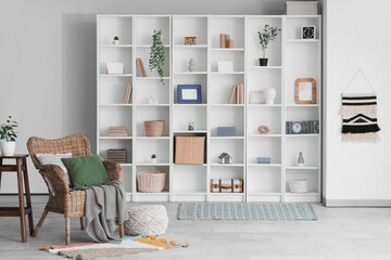 Interior of stylish modern living room with armchair and big shelving unit