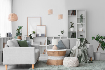 Interior of stylish modern living room with grey sofas, shelving unit and houseplants