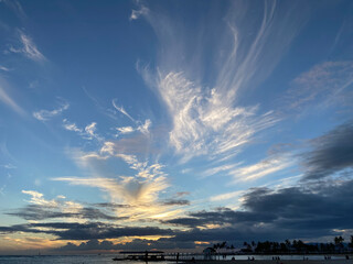 Dramatic Cloud Streaks at Sunset with Silhouettes on Pier