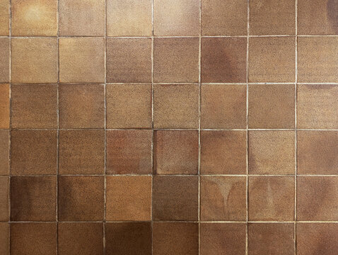 Top view of reddish brown rustic natural stoneware outdoor floor. Classic rough anti-slip matte terracotta ceramic square tiles for paving, terrace, porch, patio, pool exterior texture background. 