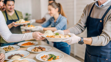 Volunteers serving hot meals to community members in need at a charity food kitchen