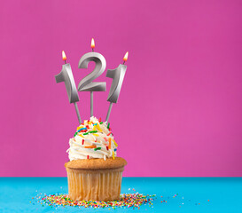 Lit birthday candle with the number 121 - Celebration card on violet and blue background