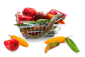Shopping supermarket basket with fresh organic ripe with assorted colorful peppers whole isolated...