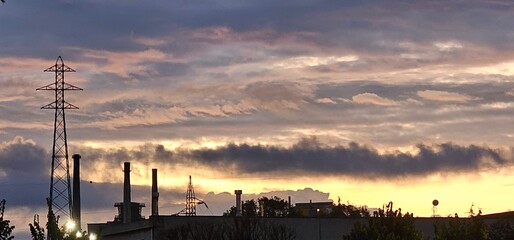 fiery sunset with smog fumes from chimneys at a metalworking industry in Italy