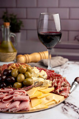 cold cuts table with assorted cheeses, Sardinian provolone and flavoured with oregano and olives, homemade bread with loin, ham, pork shoulder, bacon, salami, mortadella with nuts and a variety of col