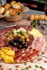 cold cuts table with assorted cheeses, Sardinian provolone and flavoured with oregano and olives, homemade bread with loin, ham, pork shoulder, bacon, salami, mortadella with nuts and a variety of col