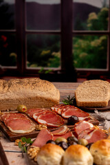cold cuts table with assorted cheeses, Sardinian provolone and flavoured with oregano and olives, homemade bread with loin, ham, pork shoulder, bacon, salami, mortadella with nuts and a variety of col