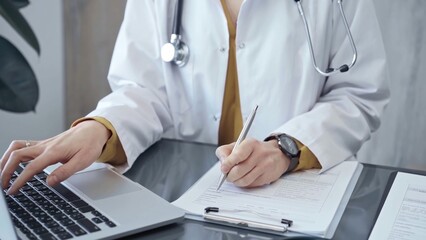 Doctor woman is working on laptop with medical reports. Healthcare professional reviews patient...