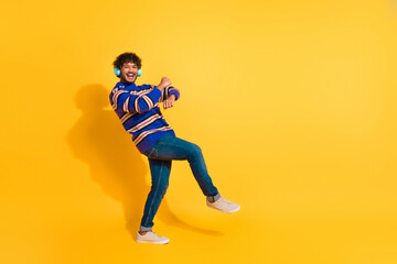 Fototapeta premium Full body photo of attractive young man headphones dance boogie woogie dressed blue striped clothes isolated on yellow color background