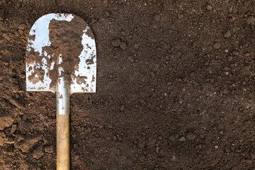 Brown dark soil ground texture background with copyspace and shovel top view. Organic farming,...