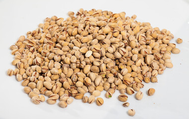 Fototapeta premium Heap of pistachios scattered on white surface