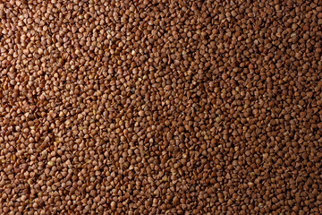 Dry Uncooked Brown Buckwheat Groats Background - Top View, Flat Lay. Raw Large Buckwheat Grains. Russian, Ukrainian and Belarusian Culture