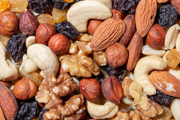Mixed Nuts: Almonds, Walnuts, Cashews, Peanuts, Hazelnuts, Dried Prunes and Raisins. Different Nut Mix. Background from Various Nuts and Dried Fruits