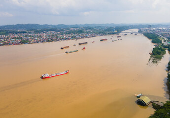 Barges carrying coal cross the Mahakam River, in Samarinda City, East Kalimantan, Indonesia. East...