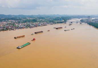 Barges carrying coal cross the Mahakam River, in Samarinda City, East Kalimantan, Indonesia. East...