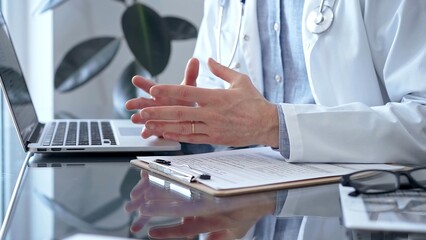 Fototapeta premium Doctor consulting patient with clipboard and a pen in his hand in medical office. Trust concept in Medicine