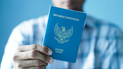 hand holding and showing Indonesian passport on blur background	