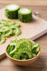Sliced bitter gourd in bowl on wooden background, Food ingredien