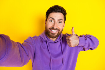 Photo portrait of nice young male take selfie photo thumb up dressed stylish violet garment isolated on yellow color background