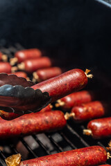 smoked sausages with red mahogany color in a collagen casing, in an offset smoker with a thick...
