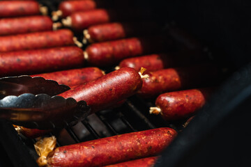 smoked sausages with red mahogany color in a collagen casing, in an offset smoker with a thick...