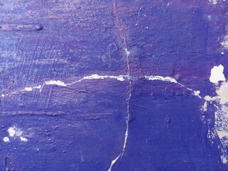 Mixed rough paint splatter on a textured blue paint surface