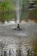 Water jet in the pond with a plastic nozzle.