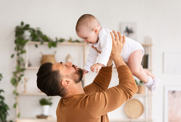 Cute Daddy Playing With Newborn Baby Daughter Cuddling And Bonding Holding Little Toddler In Arms...