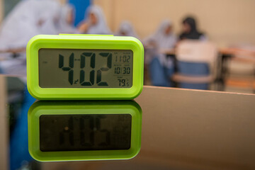 light green rectangular digital clock in the classroom