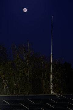 Full moon and lightning rod on the roof in the evening.
