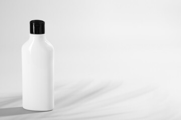 Bottle of shampoo on light background. Space for text