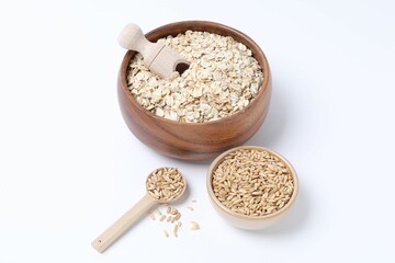 Oat flakes in bowl, grains, scoop and spoon isolated on white