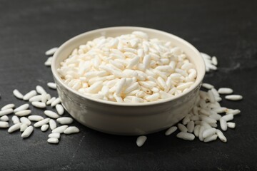Puffed rice in bowl on dark table, closeup