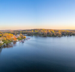 Tranquil sunset over a serene lake, capturing the peaceful reflections of fading sunlight on calm waters with silhouetted trees on the shoreline.