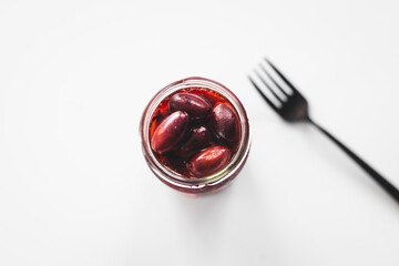 pickled kalamata olives in clear glass jar shot from above, pantry staple ingredients