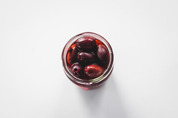 pickled kalamata olives in clear glass jar shot from above, pantry staple ingredients