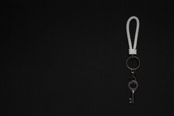 Elegant Minimalist Silver Keychain with Leather Loop on Black Background for Modern Design Concepts