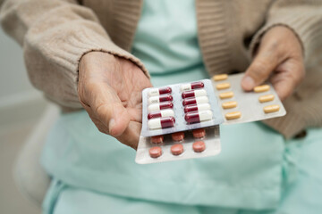 Asian elderly woman holding pill drug in hand, strong healthy medical concept.