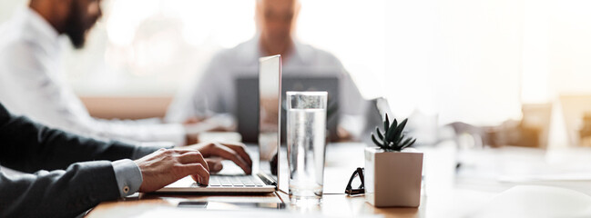 Corporate Lifestyle. Unrecognizable Businessman Working On Laptop During Business Meeting Sitting At Desk In Office. Cropped, Selective Focus, Panorama