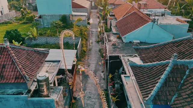 Drone moves flawlessly through Penjors. Aerial footage of traditional Balinese symbols and decorations, positioned at the entrance of each house