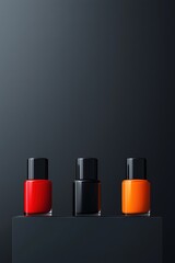Obraz premium A striking arrangement of vibrant nail polishes in red, black, and orange displayed on a sleek dark background, highlighting beauty and elegance in cosmetics.