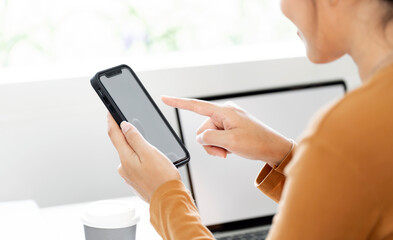 Fototapeta premium Close-up shot of woman's hands tapping on a mobile phone screen