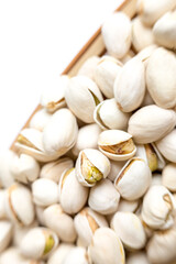 A detailed close-up view of several pistachio nuts in their shells, with some shells partially open, showcasing the nut inside. The intricate textures and natural appearance of the pistachios are high