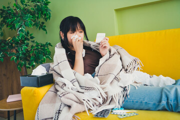 Photo of unhappy sad girl dressed t-shirt covering banket taking pills indoors house apartment room
