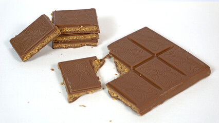 Milk chocolate bar filled with cookie dough caramel butter nuts filling with pieces stacked isolated on white background