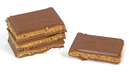 Milk chocolate pieces filled with cookie dough caramel butter nuts filling stacked isolated on white background
