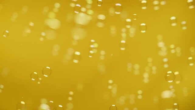 Soap bubbles falling against the yellow background. Abstract background and overlay. Slow motion. 