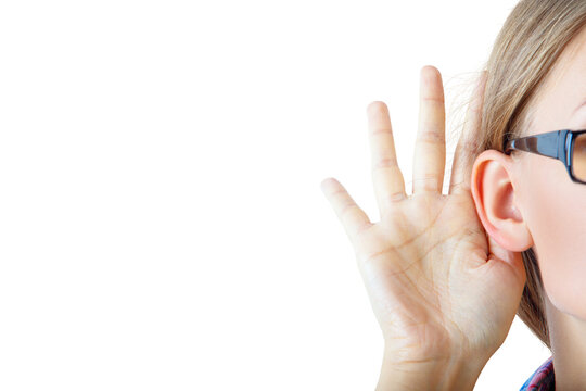 Woman with glasses holds hand to ear, listening intently. Isolated on a white background. Concept of active listening
