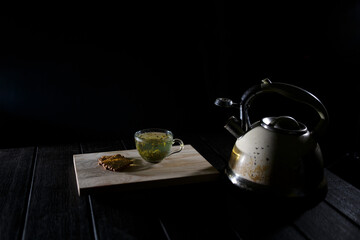 Tea still life. A cup of hot tea, a kettle and cookies. Table for tea drinking.