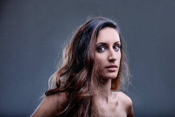 Low key portrait of a young woman with bare shoulders